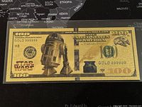 Full front view of the $100 bill with R2-D2 and Star Wars logo, gold foil plated.
