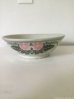 Side view of antique ceramic bowl showing hand-painted floral decoration on exterior.