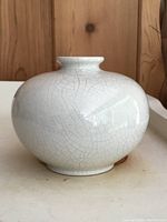 Side view of the white crackle glaze bulbous vase showing its rounded shape and crackle pattern.