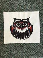 Full view of original painting of owl on paper laid on carpet, showing design and condition.