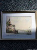 Framed original watercolor painting showing church and riverside scene with bridge in background.
