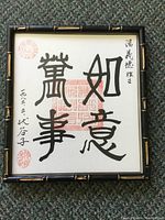 Front view of framed original Asian character ink on paper art, showcasing calligraphy and red stamps in a bamboo style frame.