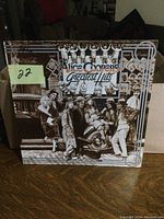 Front cover of Alice Cooper Greatest Hits LP vinyl album showing sepia-tone illustration with group of people and vintage car.