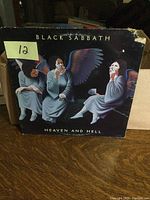 Front cover of Black Sabbath Heaven and Hell album with angels artwork, showing wear and the torn top right corner of the jacket.