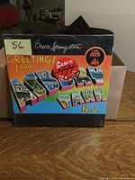 Front cover of LP album with colorful Greetings From Asbury Park N.J. artwork and Bruce Springsteen signature.