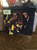 Front cover of Cheap Trick At Budokan LP showing two band members performing with microphone and guitar in vibrant colors.