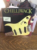Front cover of Chilliwack Sequel LP record depicting yellow guitar body graphic and album title.