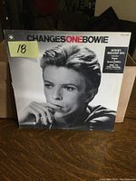Front cover of ChangesOneBowie album by David Bowie showing black and white portrait and album title.