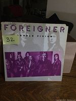 Front cover of Foreigner Double Vision LP with purple tint photo of band members and title.