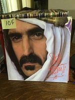 Front cover of the LP showing Frank Zappa wearing a white and gold headscarf with the title 'Sheik Yerbonti' in red.