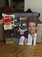 Front of the Huey Lewis and The News Sports album showing band members and album title with a Sam's Club Special sticker.