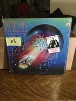 Front cover of Journey Escape vinyl record showing stylized scarab beetle design and shrink wrap with promotional sticker.