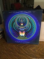 Front cover of Journey Captured album featuring scarab insect artwork on blue background