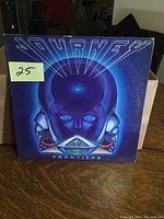 Front cover of Journey 'Frontiers' LP album with blue sci-fi robotic head artwork and yellow price sticker.
