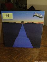 Front vinyl album cover showing title 'Point of Entry' by Judas Priest with blue road and sunset design.