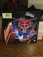 Front cover of Judas Priest Defenders of the Faith LP showing colorful robot horned creature artwork.
