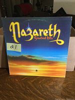 Front cover of the vinyl album 'Greatest Hits' by Nazareth, showing colorful sunset sky and band logo.
