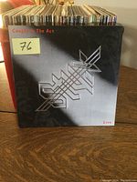 Front cover of Styx live album "Caught in the Act" showing stylized sword graphic and album title.