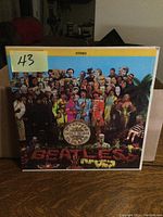 Front cover of The Beatles Sgt. Peppers Lonely Hearts Club Band LP showing colorful collage artwork and album title.