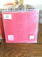 Back side of a red lyric sleeve showing printed lyrics, with indication of Paper Label S A M'S on lower right corner.