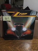 Front cover of ZZ Top 'Eliminator' vinyl LP showing vintage red car artwork and band logo