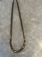 Full view of the braided rope necklace showing its length and overall condition.