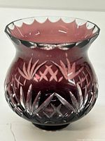 Side view showing maroon color and detailed cut leaf and star motifs on the crystal candle holder.