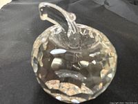 Top and angled view showing the faceted surfaces and clear crystal material of the apple paperweight.