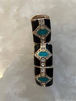 Close-up photo of the black and teal geometric rhinestone bracelet with gold-tone metal.