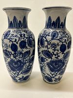 Pair of blue and white Asian vases front view showing matching floral and leaf patterns