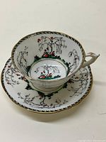 Top view of the teacup placed on saucer displaying floral and branch pattern inside and outside the cup as well as on the saucer.