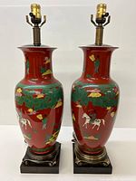 Pair of red porcelain table lamps with brass hardware on wooden bases