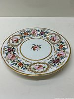 Full view of the antique Coalport plate with floral and gold pattern.