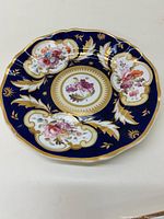 Full view of the antique Coalport porcelain plate showing the blue, gold, and floral hand painted design.