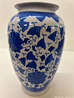 Front view of a 12-inch porcelain vase with blue floral and leaf patterns on white background, showing minor wear.