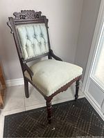 Full view of East Lake parlour chair showing carved wood frame and upholstered seat with some wear.