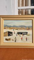 Frontal view of framed oil painting by K. Carty showing winter ice skating scene