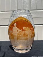 Front view of the leaded crystal vase showing etched design of two golfers against an amber background.