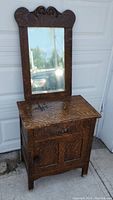 Full view of the wooden washstand with hanging mirror showing overall condition and size.