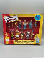 Front view of unopened Simpsons character collection box showing all 12 figurines in window display.