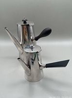 Photo of both silver plated hot chocolate pots together, showing their size difference and design.