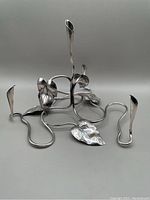 Full view of metal calla lily candleholder showing four candle holders, several leaves and curving vine design.
