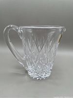 Side view of Waterford Kinsale crystal jug showing clear cut diamond pattern, curved handle, and pouring spout.