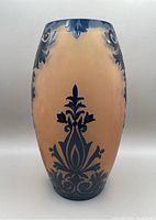 Front view of tall navy blue and golden cameo glass vase showing floral and scroll details
