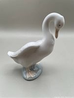 Side view of the Lladro Nao porcelain goose figurine showing detailed sculpting of the neck, wings, and base.