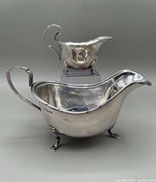 Front view of both gravy and sauce boats on neutral background