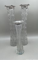 Front view showing all three cut crystal vases with sterling rims, two taller matching and one shorter.