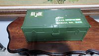 Closed green metal GI Joe army case with white printed markings and latch on front.