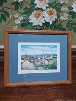 Framed and matted print with wooden frame featuring townscape with clustered church spires by Harry Richardson.