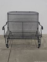 Front view of black metal outdoor loveseat glider showing mesh design and curved armrests.